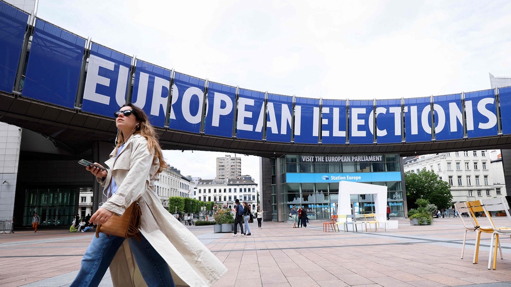 Frau schreitet flott über einen Platz - Werbung für EU-Wahl