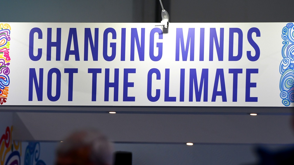 Ein Plakat auf dem "Changing MInds, not the Climate" steht
