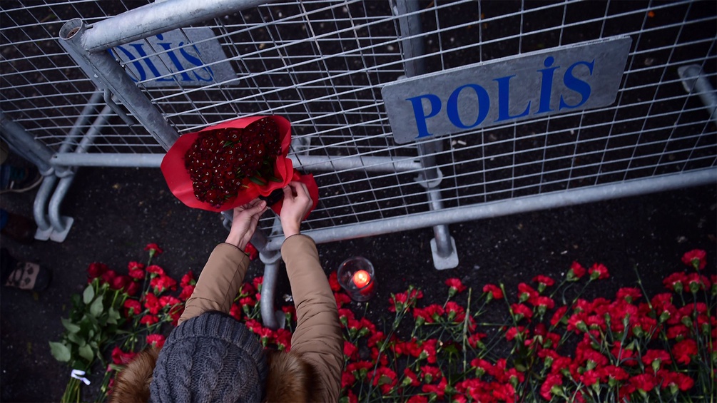Blumen vor einer Polizeiabsperrung