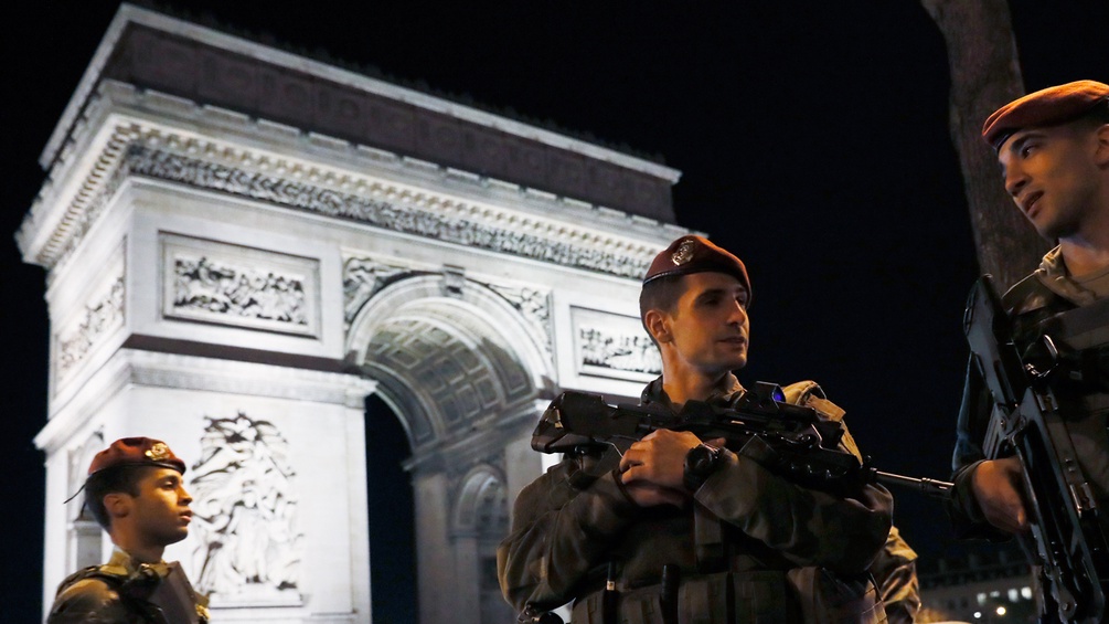 Polizisten vor dem Pariser Triumphbogen nahe der Champs-Elysees
