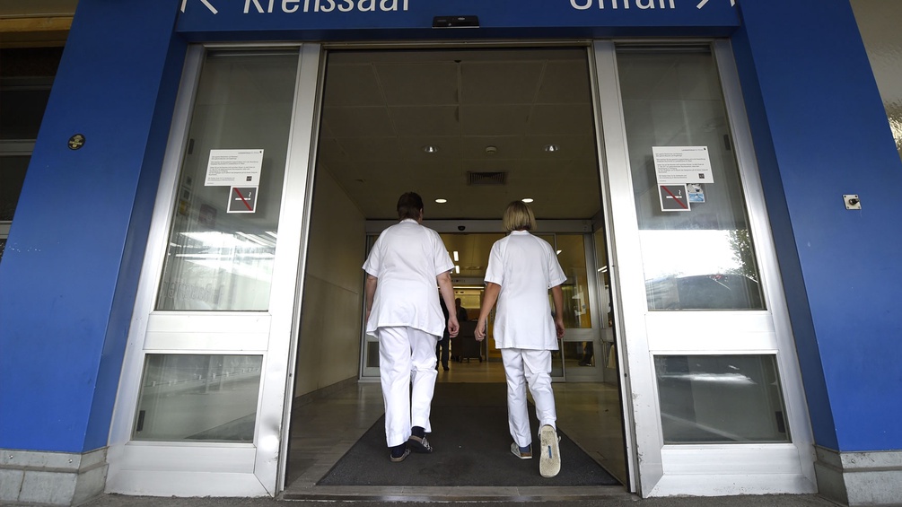 Zwei Ärztinnen betreten ein Krankenhaus.