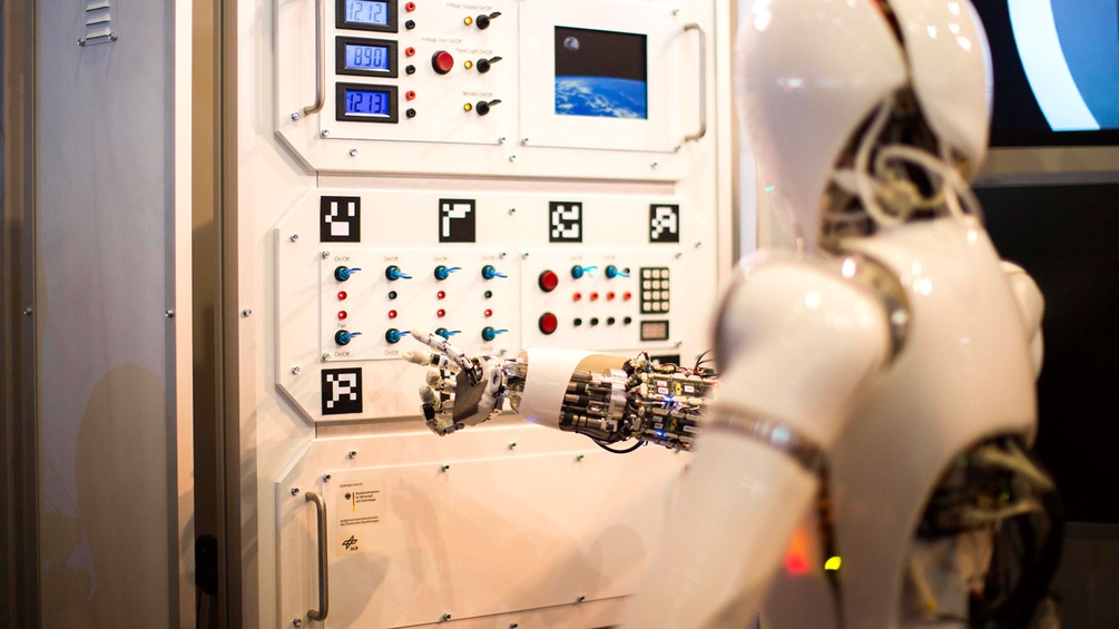 Ein weißer Roboter bedient eine Maschine.