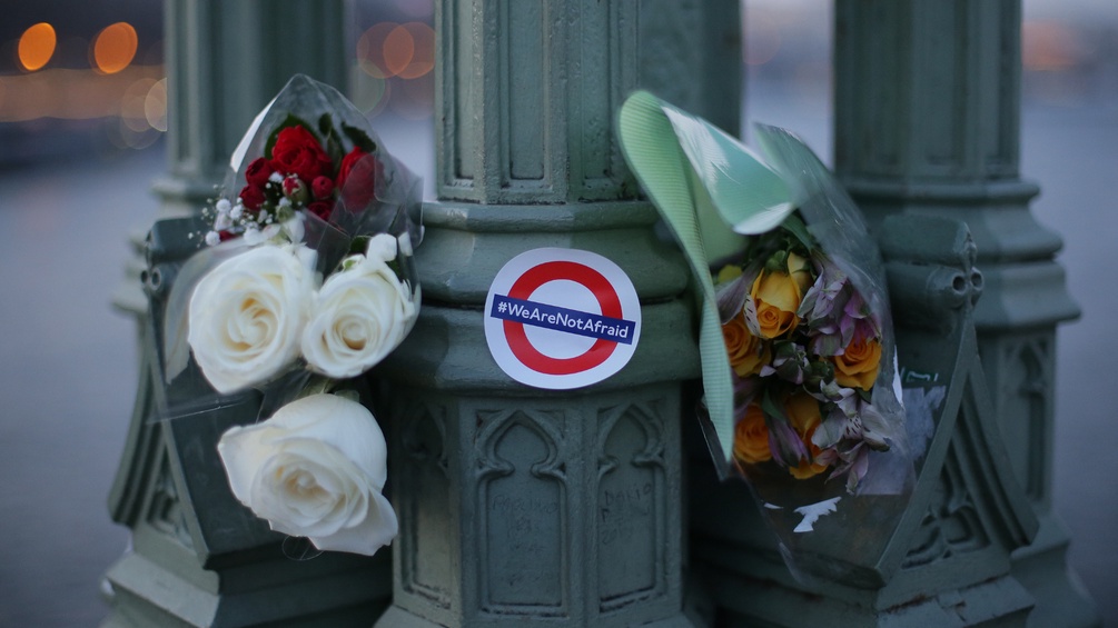 Blumen und Aufkleber mit dem Logo der Londoner U-Bahn mit der Aufschrift "We are not afraid"