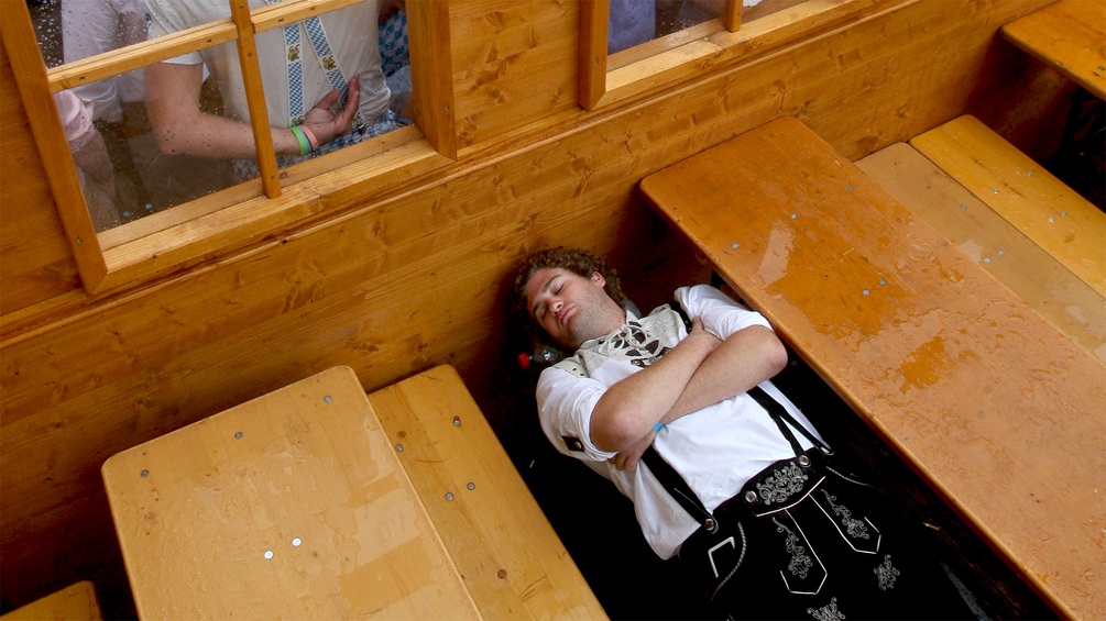 Ein junger Mann schläft auf der Bank eines Gasthauses
