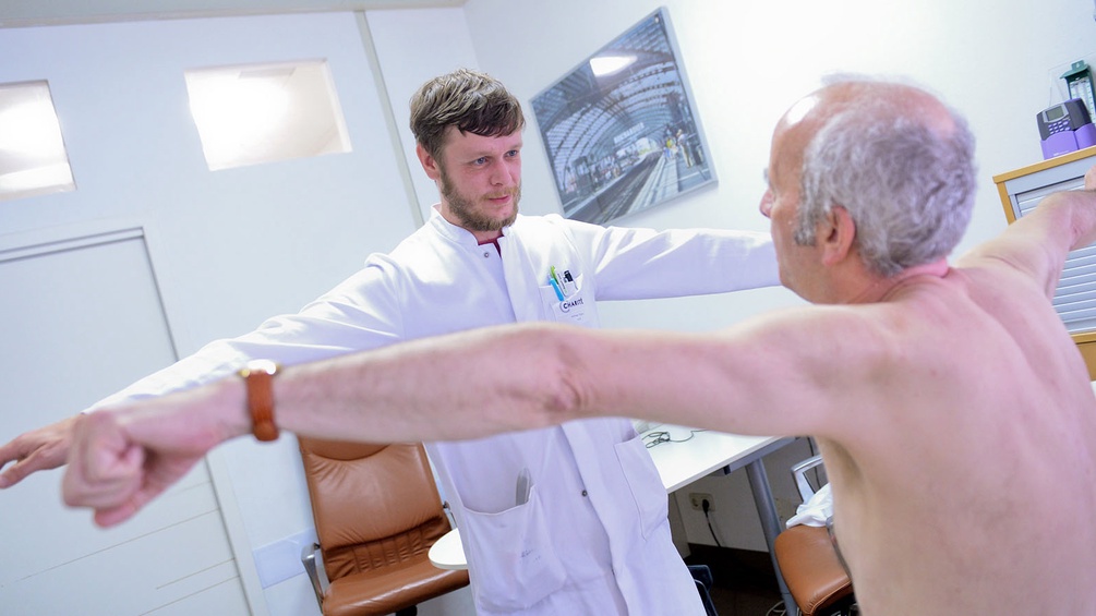 Arzt untersucht Muskeln eines Patienten