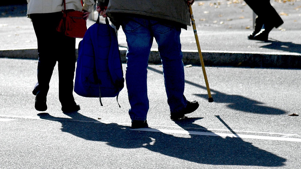 Zwei Pensionisten gehen über die Straße