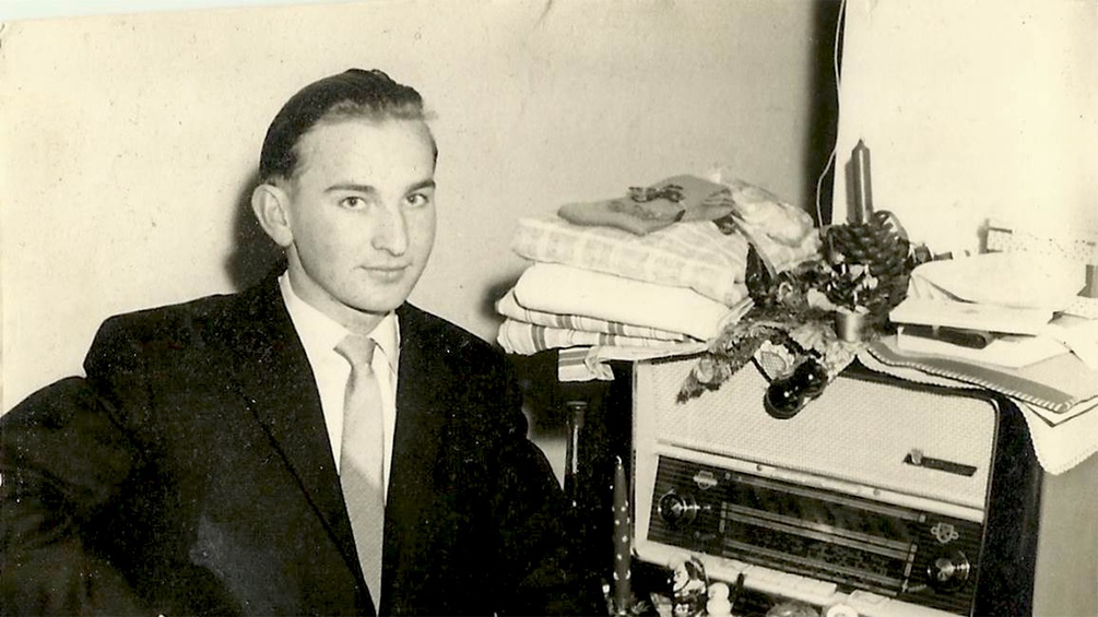 Historisches SW-Foto eines jungen Mannes neben einem Radioapparat