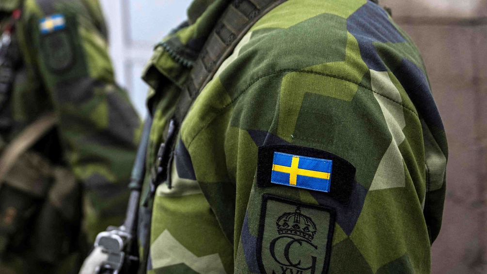 Schwedischer Soldat in Uniform, schwedische Fahne