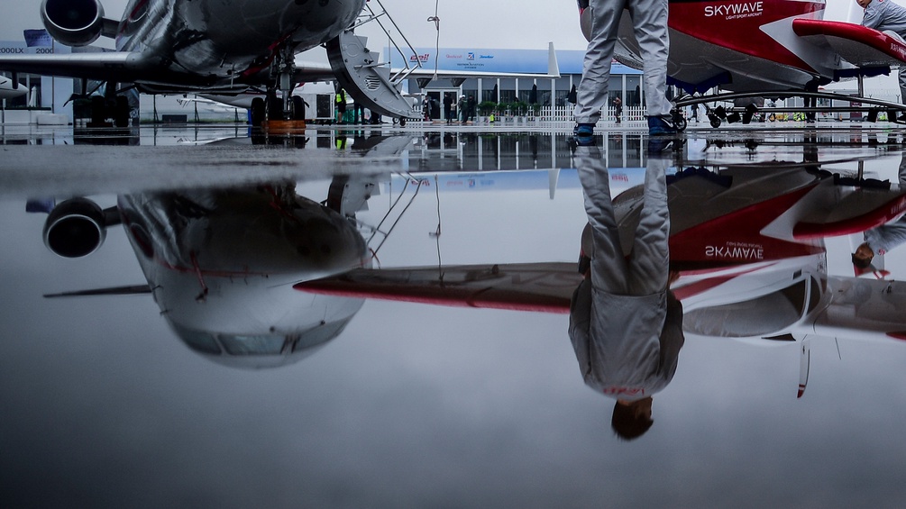 Spiegelung zweier Flugzeuge auf nassem Boden