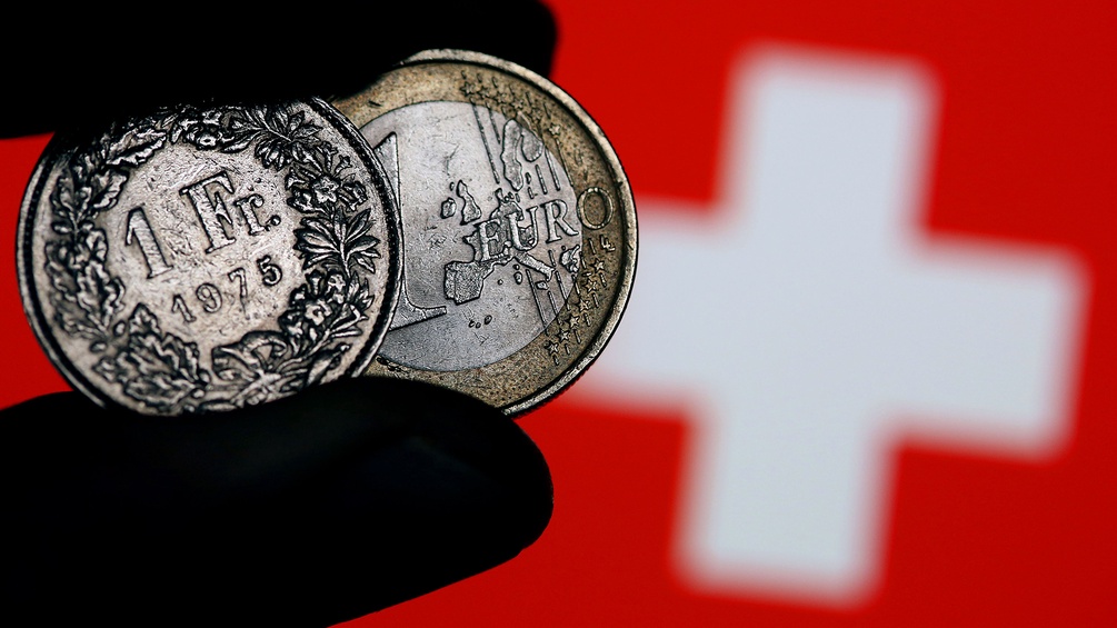 Schweizer Flagge und Euromünzen