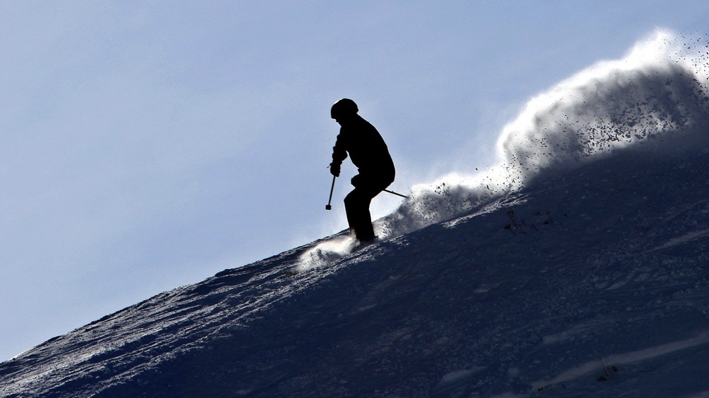 Ein Skifahrer fährt einen Hang hinunter