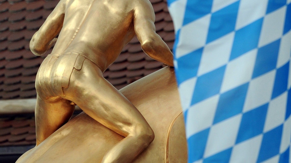 Goldene Statue und bayerische Flagge