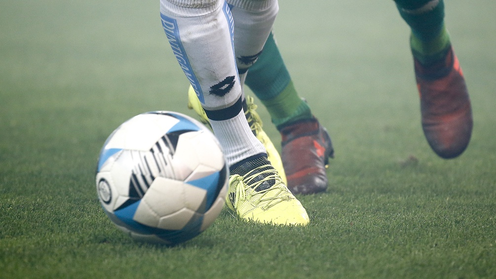 Ein Ball und die Beine von zwei Fußballspielern