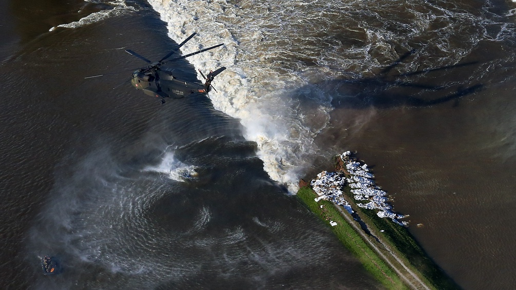Hubschrauber über einem Dammbruch an der Elbe