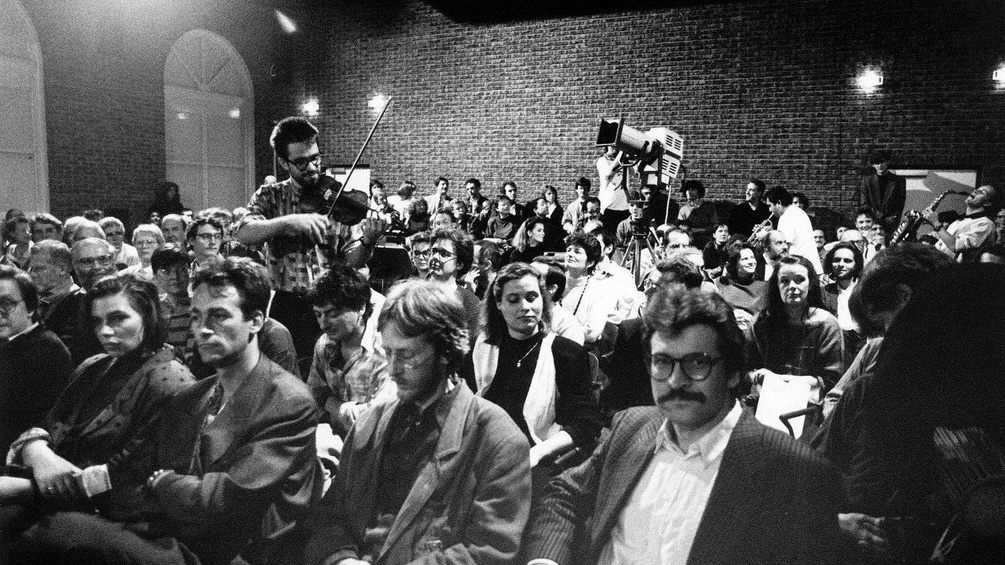 Peter Oswald beim Abschlusskonzert des von ihm programmierten musikprotokoll 1989 neben dem Komponisten Gerd Kühr sitzend)