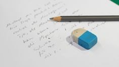 Stift und Radiergummi liegen auf einer Notiz