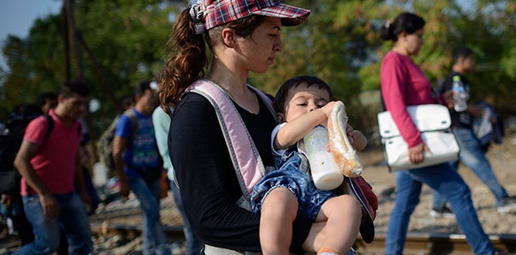 Migrantin trägt ihr Kind