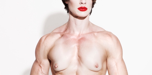 Muskulöser Mann mit weiblichen Brüsten und geschminkten Lippen