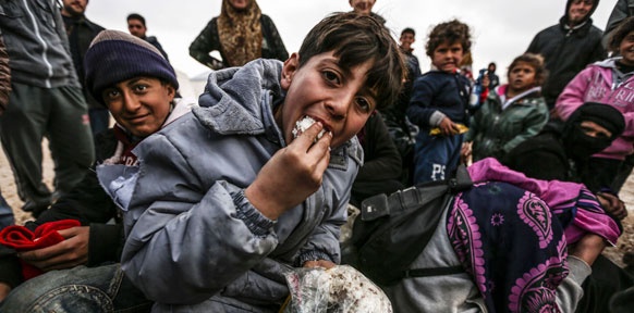Syrische Flüchtlinge mit Regenumhängen