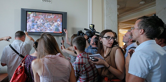 Journalisten schauen eine Übertragung des Parlaments in Kiev an
