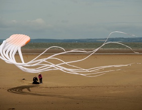 Paar lässt am Strand einen Drachen steigen