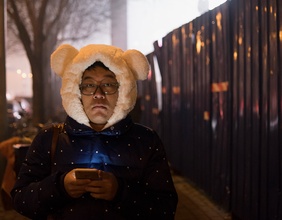 Mann mit Smartphone und Bärenhaube