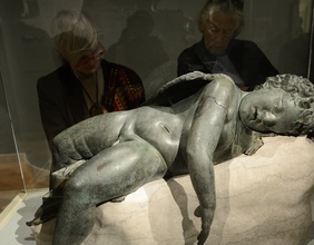 Museumspublikum vor einer liegenden Eros-Statue