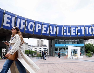 Frau schreitet flott über einen Platz - Werbung für EU-Wahl