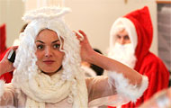 (c) Kumm, dpa Frau als Christkind verkleidet, ein Weihnachtsmann im Hintergrund