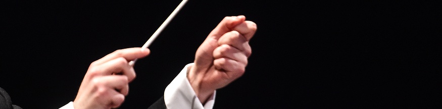 Ein Dirigent hält einen Dirigentenstab