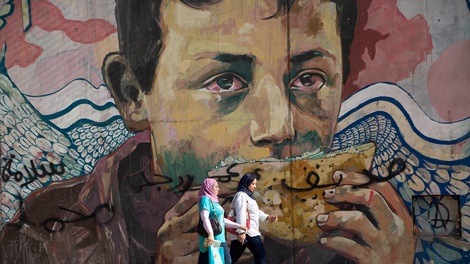 Zwei Frauen gehen an einer Wandmalerei in Kairo vorbei