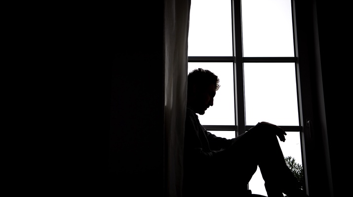 Ein Mann sitzt an einem Fenster.