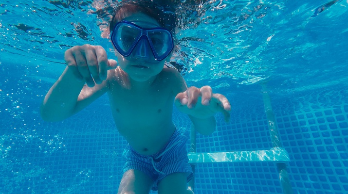 Tauchendes, schwimmendes Kind in einem Schwimmbecken