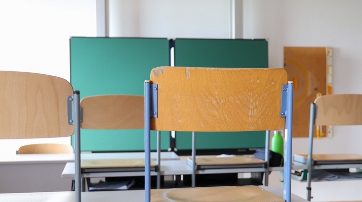 Klassenzimmer: Hochgestellte Stühle und Tafel