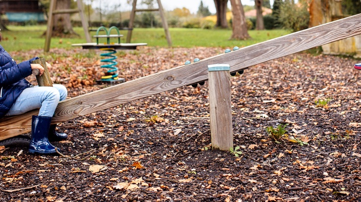 Kind auf einer Wippe, Spielplatz