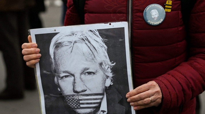 Julian-Assange-Plakat in Händen einer Frau
