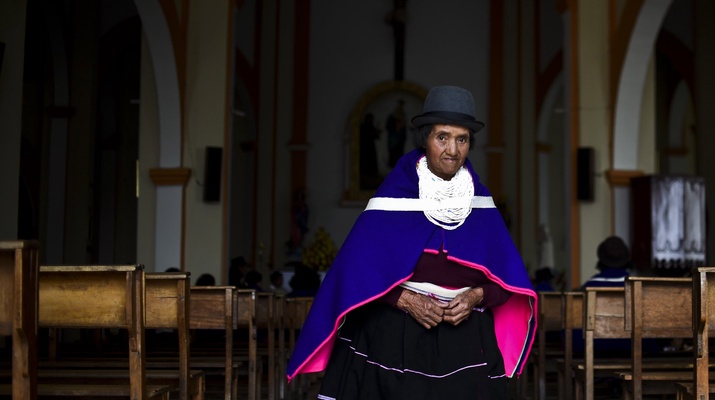 Indigene kolumbianische Frau verlässt ein Kirchengebäude
