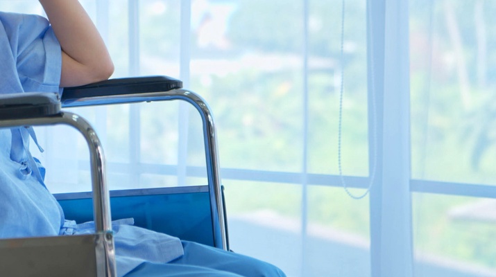Dame in einem Rollstuhl in einem Krankenhaus am Fenster