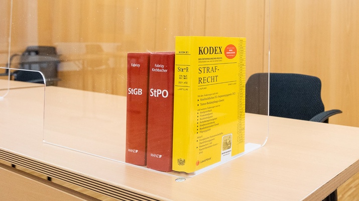 Gerichtssaal mit juristischen Sachbüchern: Kodex und StGB, StPO