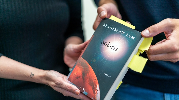 Zwei Menschen halten das Buch Solaris