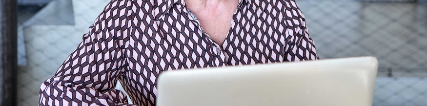 Ältere Arbeitnehmerin vor Laptop