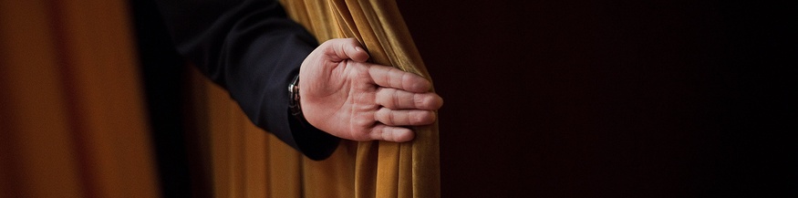 Hand öffnet einen Vorhang
