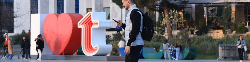 Mann mit Smartphone in Tirana, Albanien