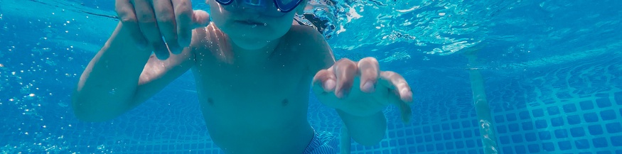 Tauchendes, schwimmendes Kind in einem Schwimmbecken