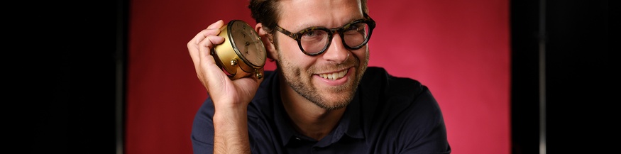 Till Köppel mit einem Wecker im Ö1 Studio