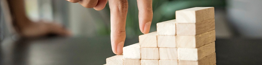 Finger steigen eine kleine Holzstiege hoch