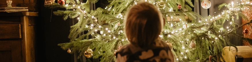 Kleines Kind vor dem Christbaum