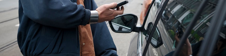Car sharing: Mann mit Smartphone öffnet Auto