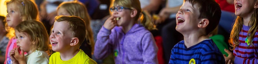 Kinder lachen beim Film schauen am Kinder Kurzfilm Festival