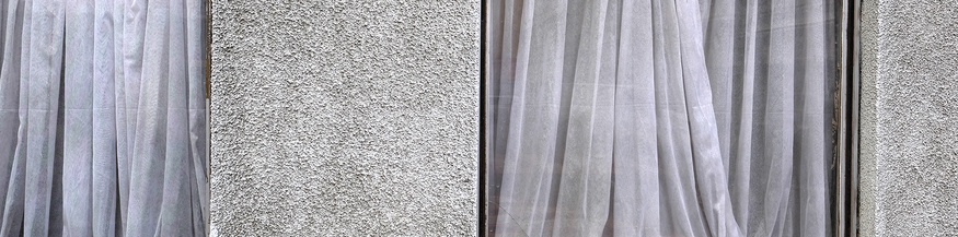 Tristes Fenster mit schmutzigen Vorhängen